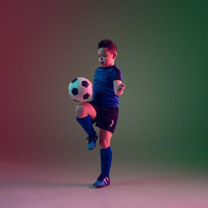 jogador-de-futebol-ou-futebol-masculino-adolescente-menino-em-fundo-gradiente-na-luz-de-neon-movimento-acao-conceito-de-atividade_155003-11199